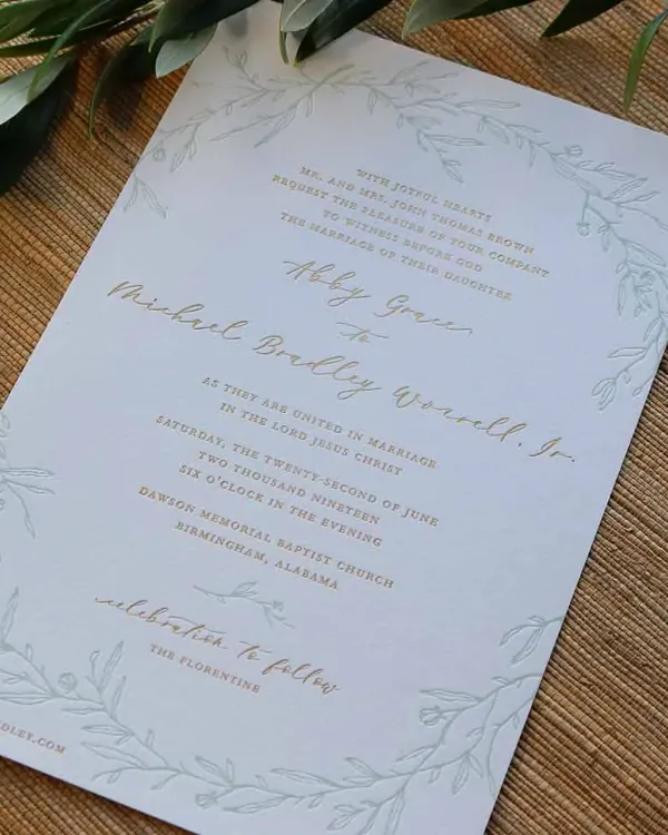 Letterpress and gold foil wedding invitation with floral design on white cotton paper