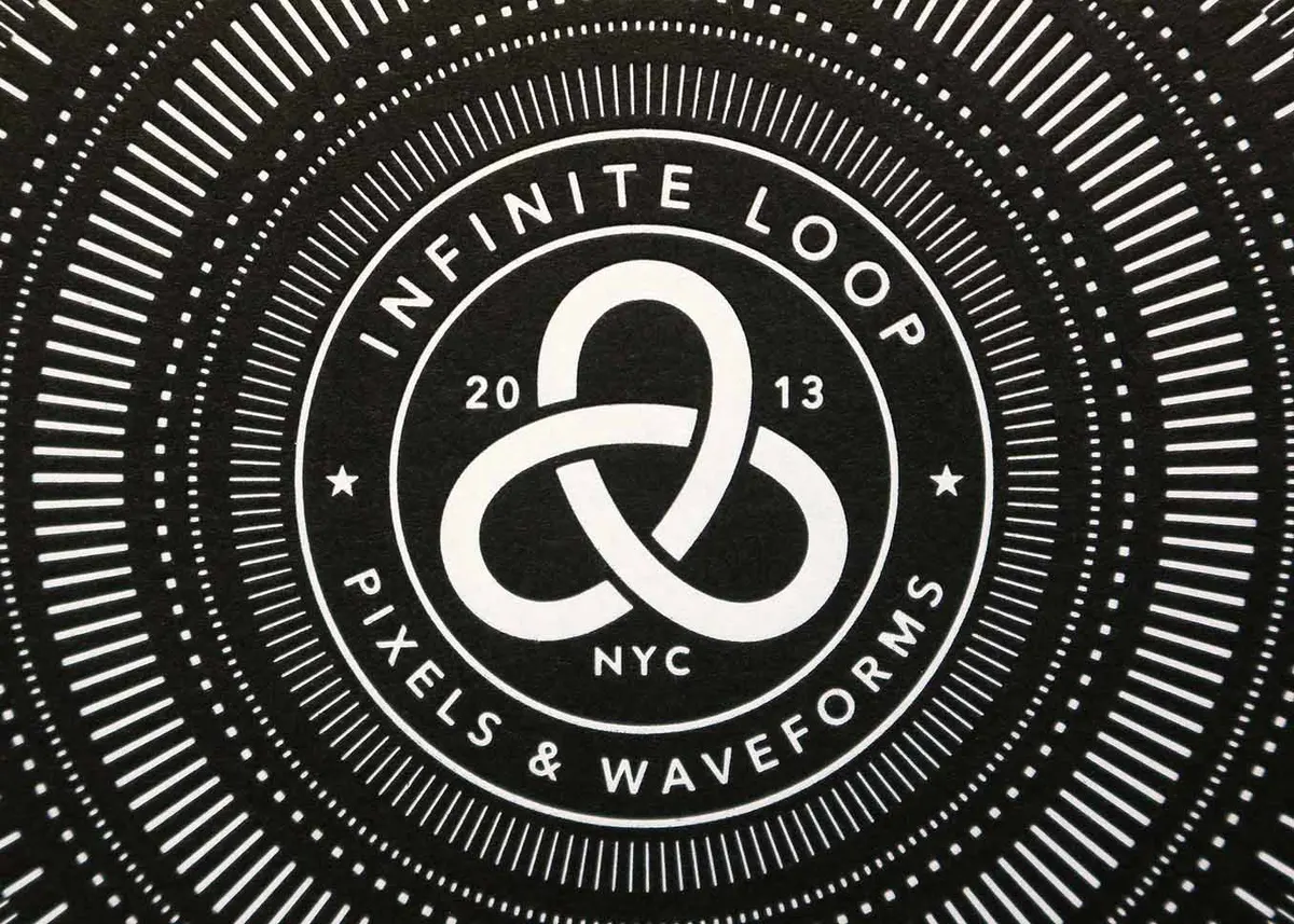 White foil business cards spread across solid black stock