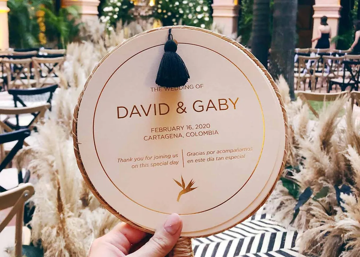 Round ceremony program with gold foil paired with Colombian fan