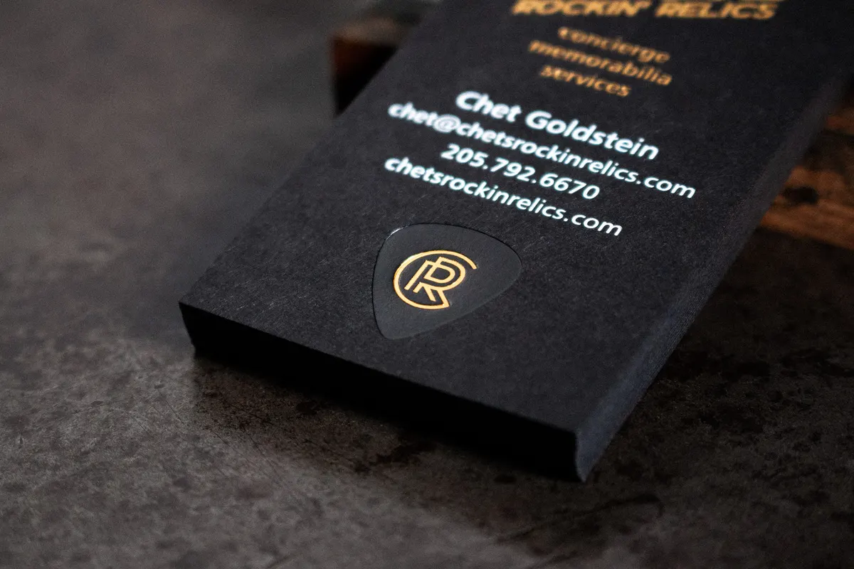 Spread of triple-foil letterpress business cards on black cover stock