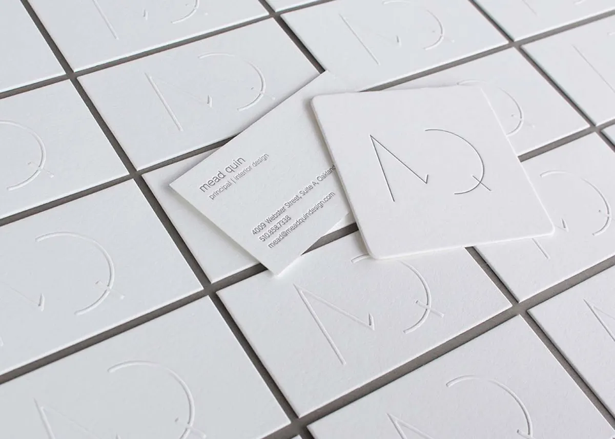 Business card with die-cut corners showing fine letterpress detail on cotton paper