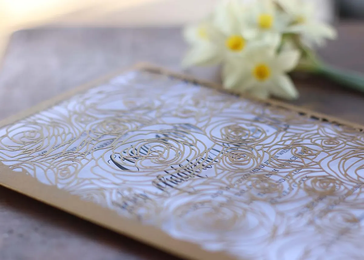 Close-up of deep letterpress impression in black ink on thick white cotton paper showing script typography