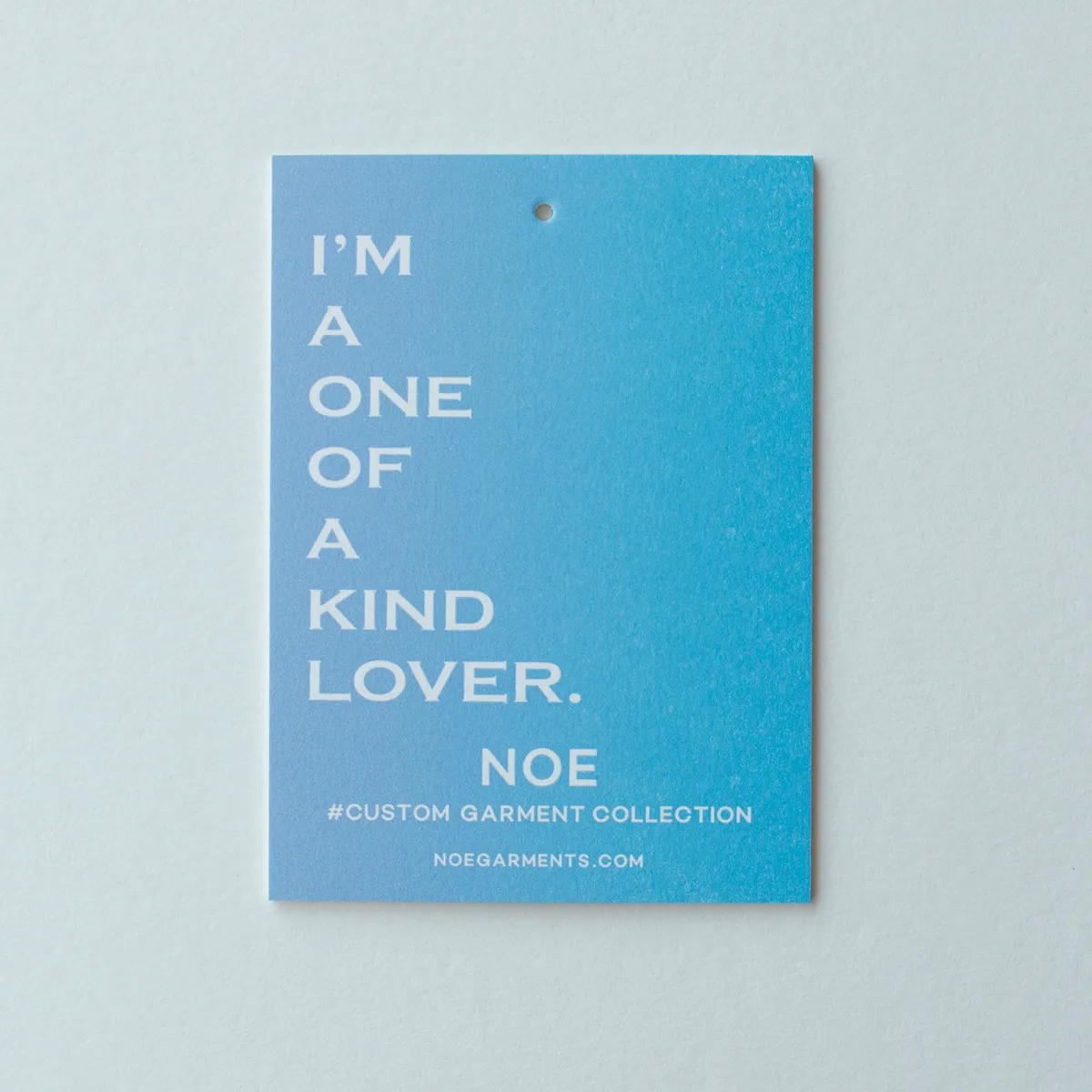 Single hang tag with a light-to-deep blue split fountain gradient on textured letterpress paper