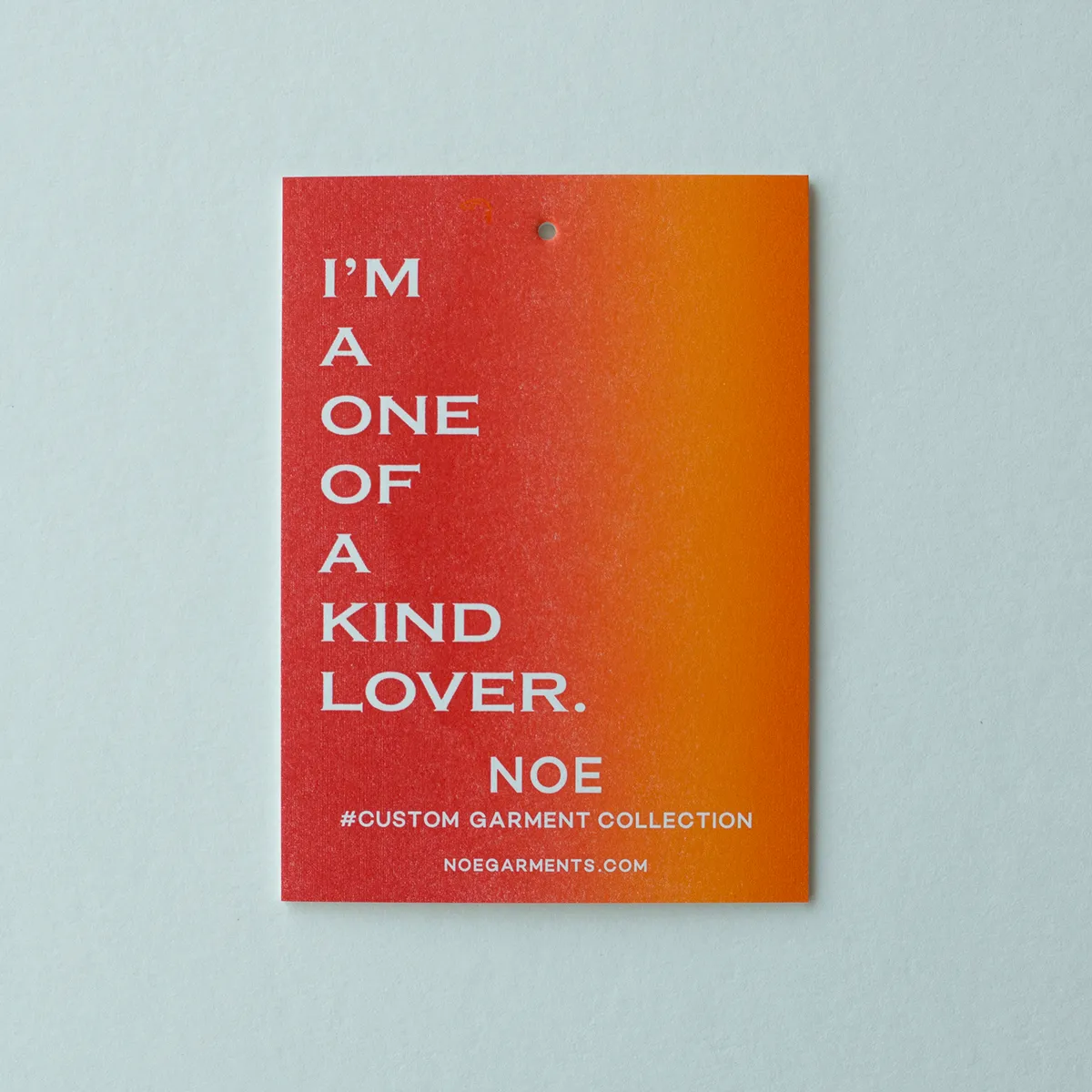 Single hang tag with a red-to-orange split fountain gradient and reversed white typography reading I'm A One Of A Kind Lover